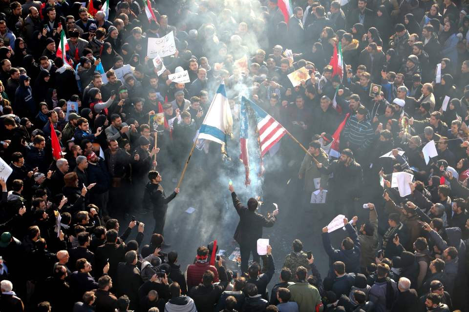 a crowd of people holding flags including one that says ' freedom ' on it