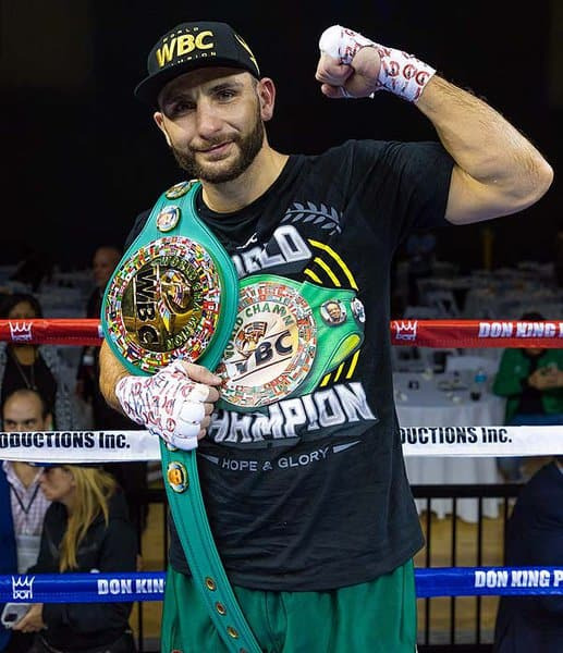 a man in a boxing ring holding a wbc belt