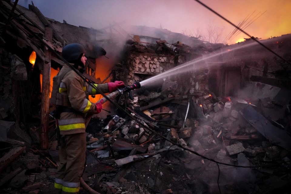 a fireman is spraying water on a fire with a hose
