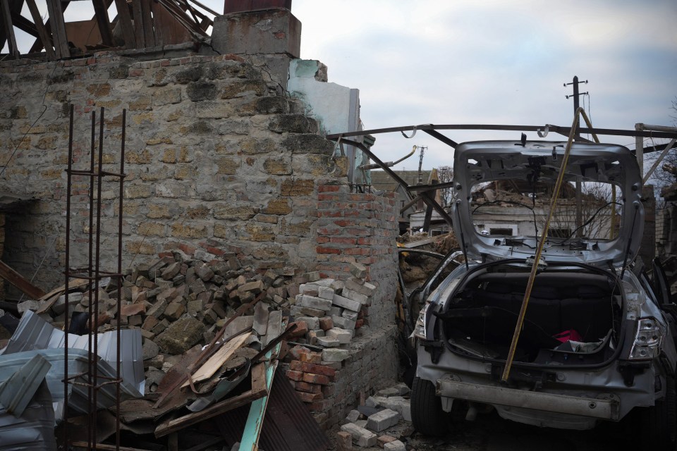 a car is sitting in front of a brick wall with its trunk open