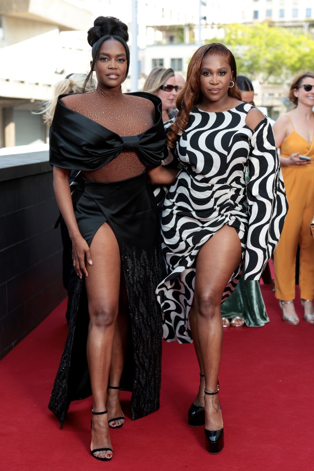 two women standing next to each other on a red carpet