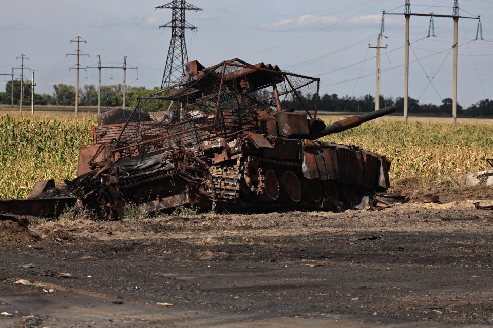 a rusted tank sits in the middle of a field