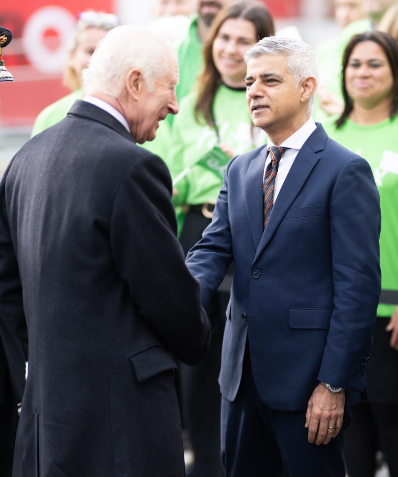 a man in a suit and tie shakes hands with another man