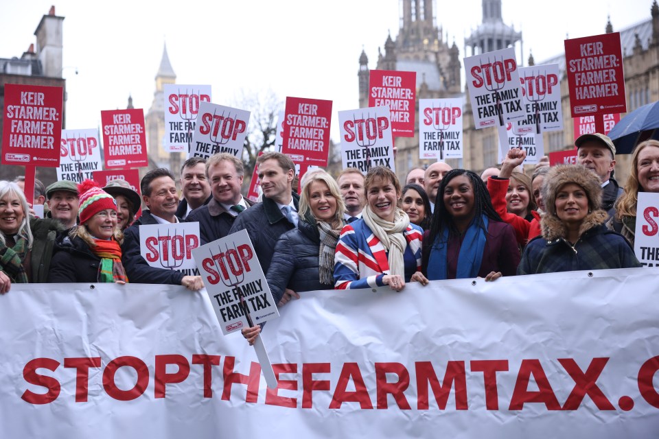 a group of people holding signs that say stop the farm tax