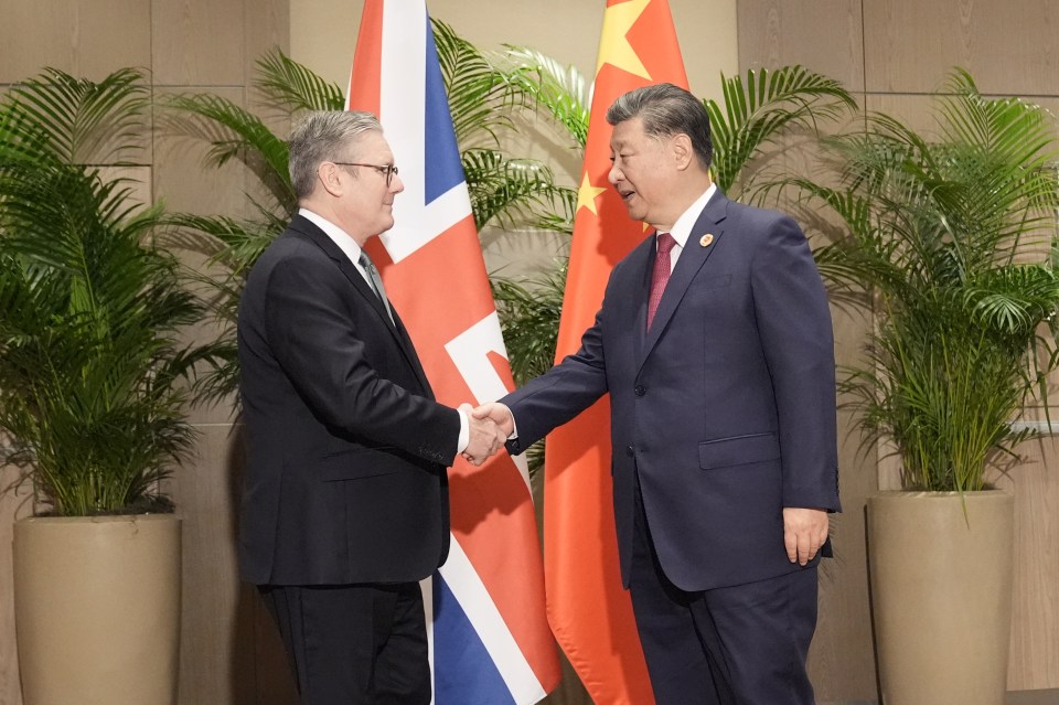 two men are shaking hands in front of flags
