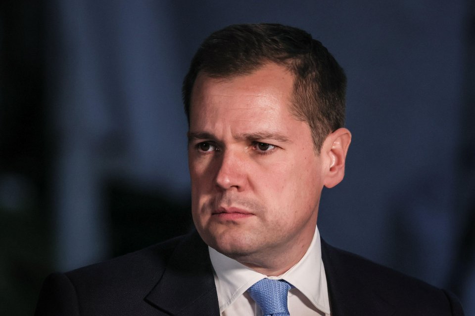 a man in a suit and tie looks at the camera