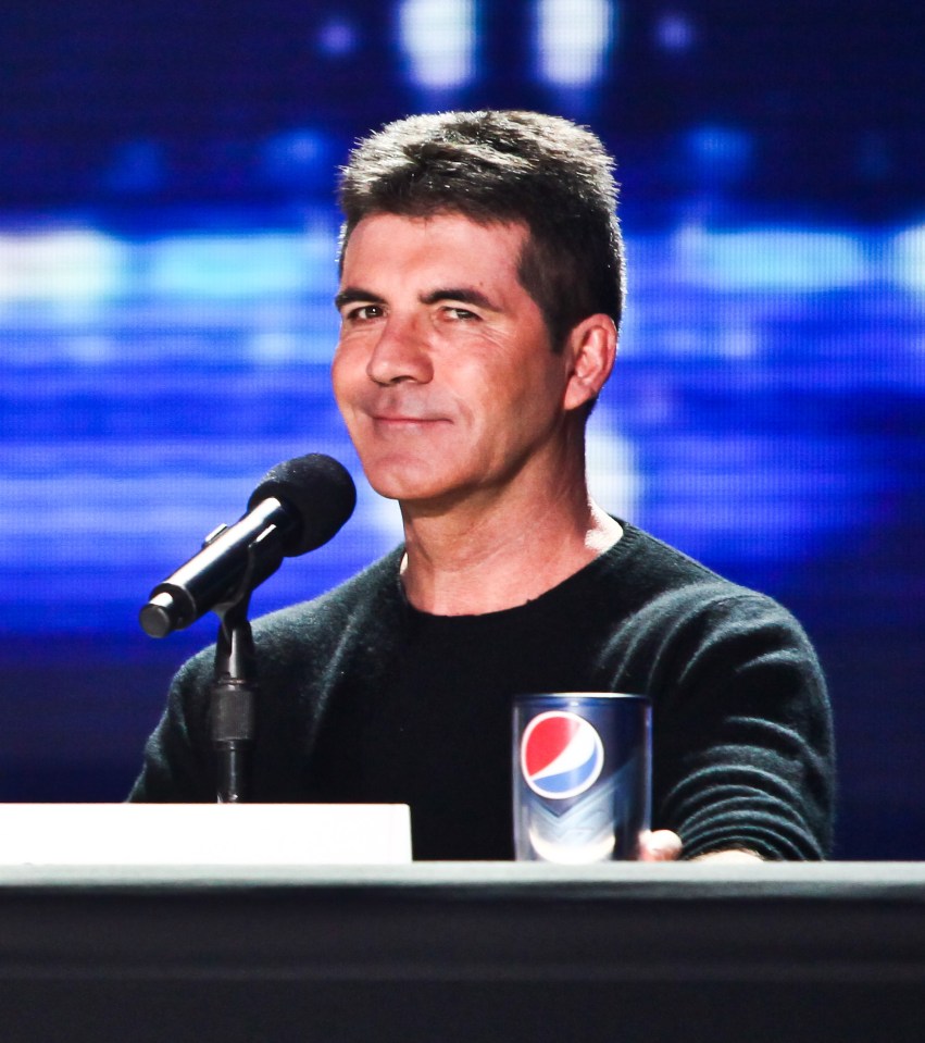 a man sitting at a desk with a pepsi glass in front of him