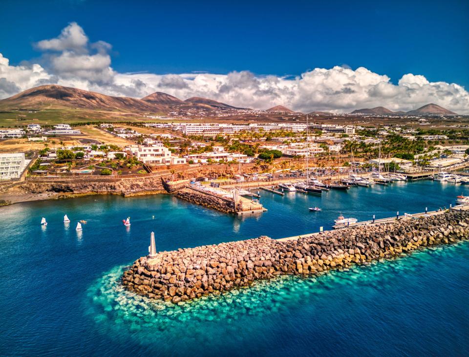 boats are docked in a harbor with mountains in the background