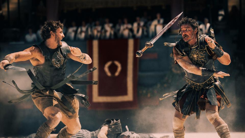 two men are fighting with swords in front of a banner with the letter o on it
