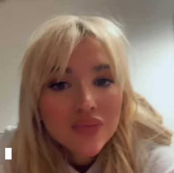 a close up of a woman 's face with blonde hair and a white shirt .