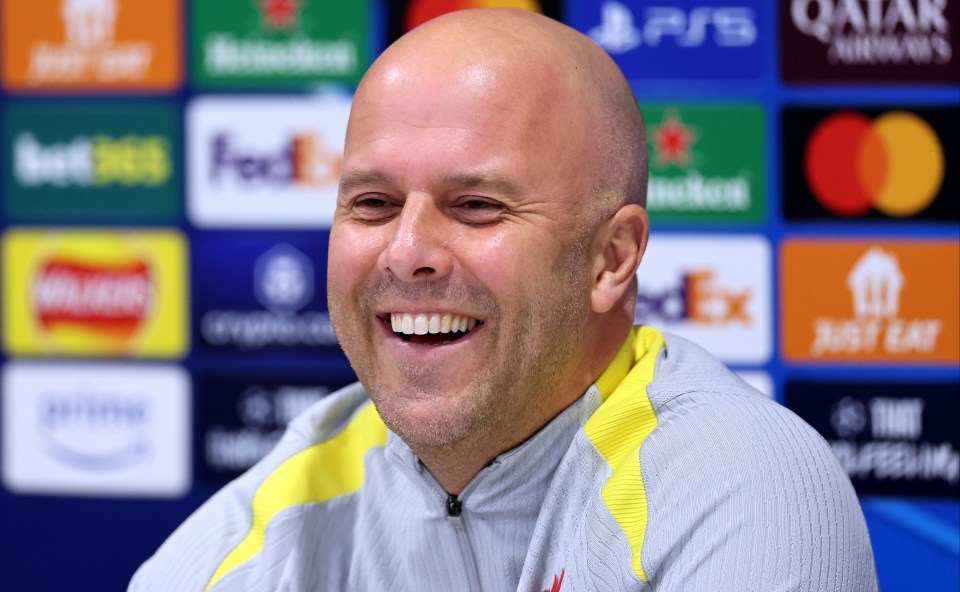 a man is smiling in front of a qatar logo