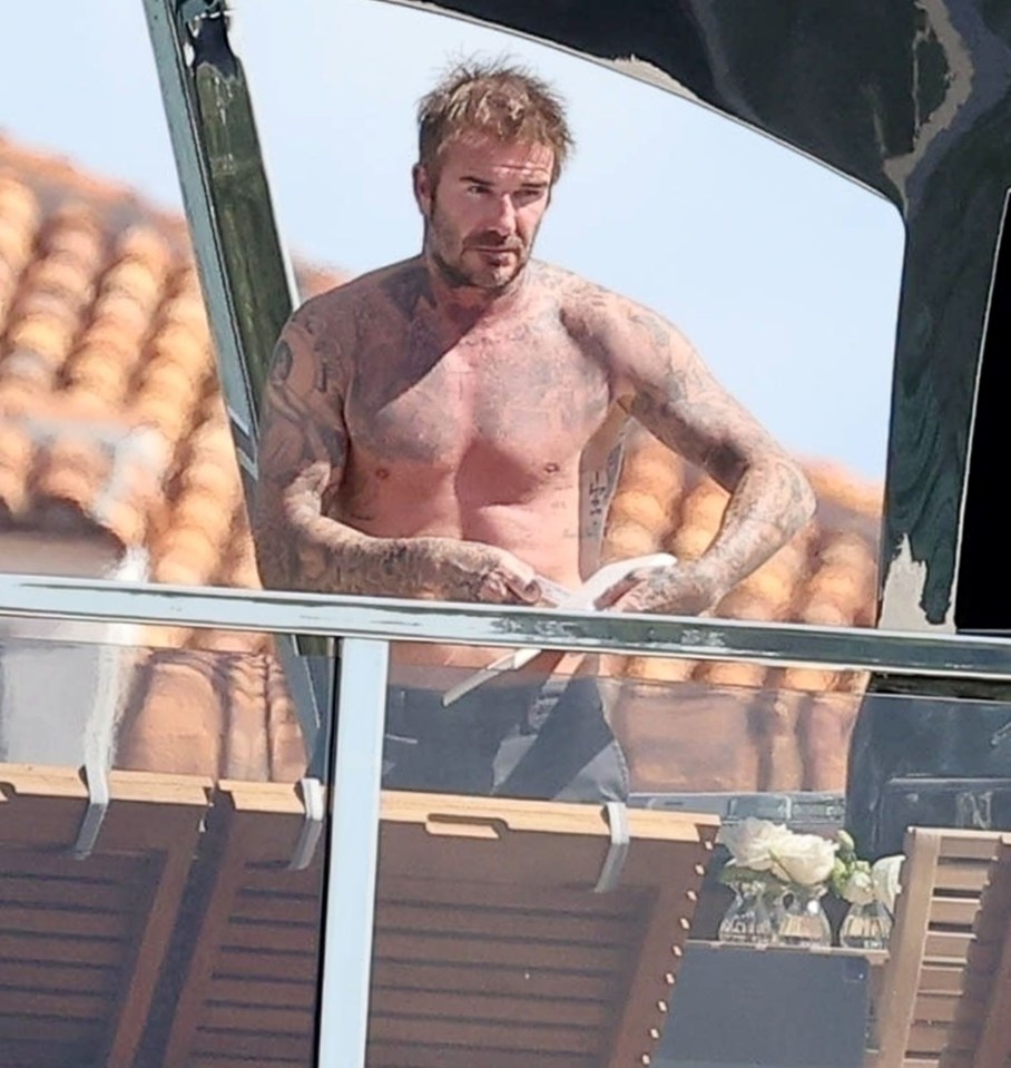 a man without a shirt is standing on a balcony