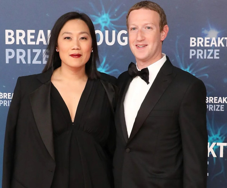 a man and a woman pose for a photo in front of a wall that says breakthrough prize