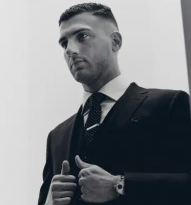 a man in a suit and tie is giving a thumbs up