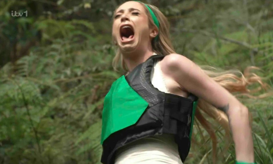 a woman in a green vest is screaming in the woods on itv 1