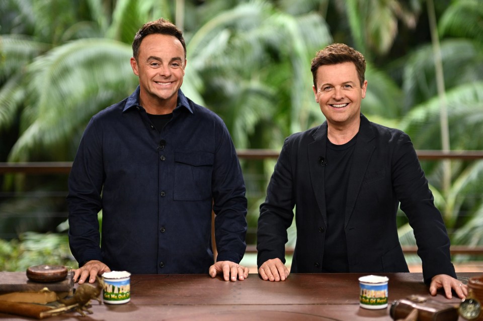 two men standing next to each other in front of a table
