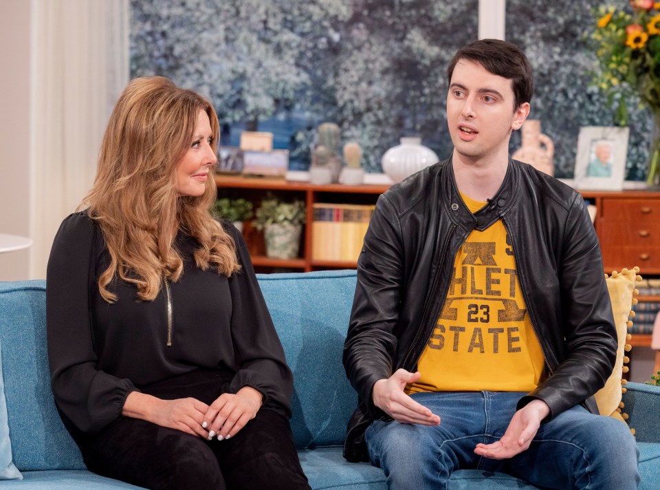 a man wearing a yellow athletic state shirt sits next to a woman