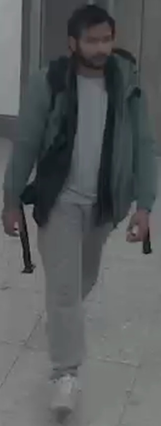 a man with a beard is walking down a sidewalk .