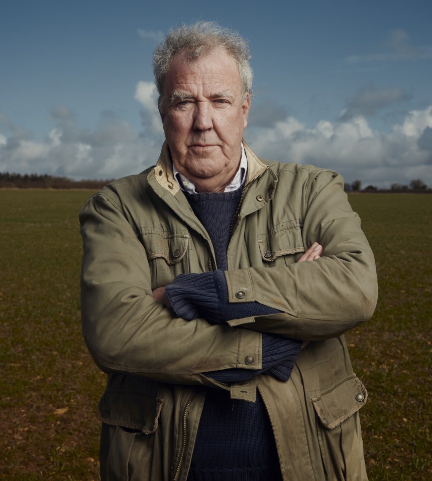 a man standing in a field with his arms crossed