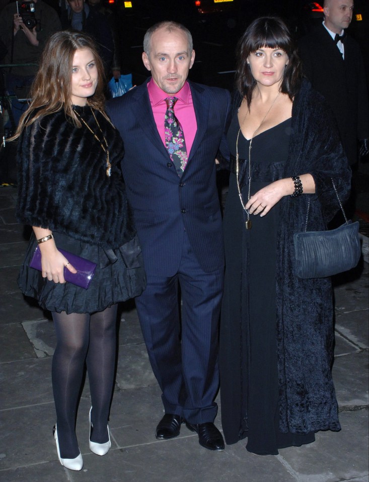 a woman in a black dress stands next to a man in a suit and tie