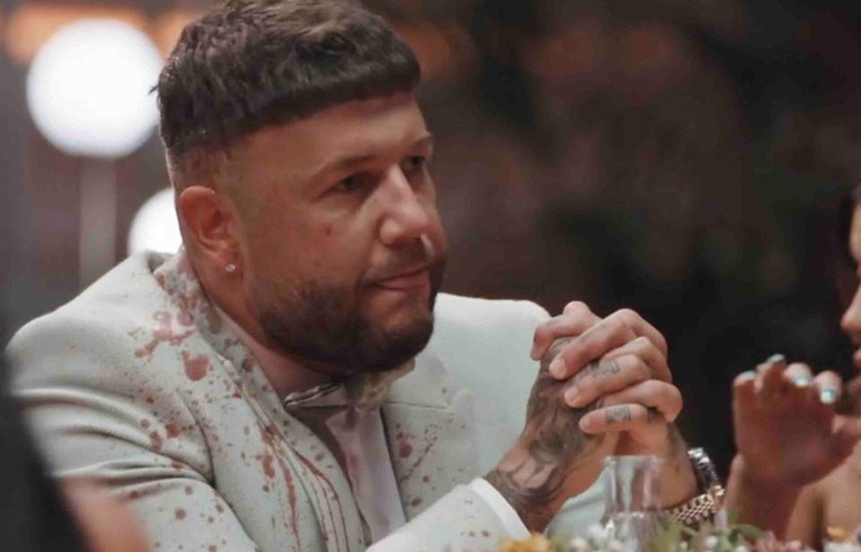 a man in a white suit has a tattoo on his hand that says ' i love you '
