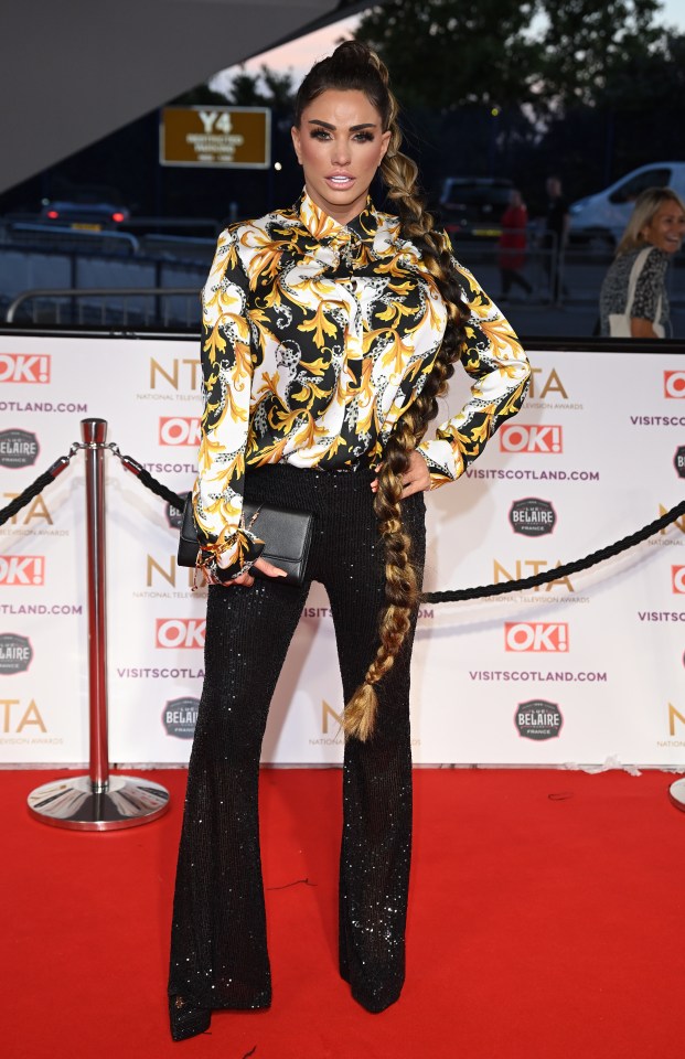 a woman stands on a red carpet in front of a sign that says ok