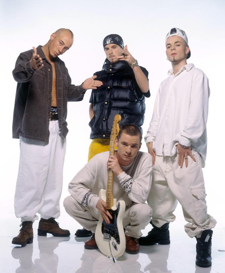 a group of men posing for a picture with one man holding a guitar