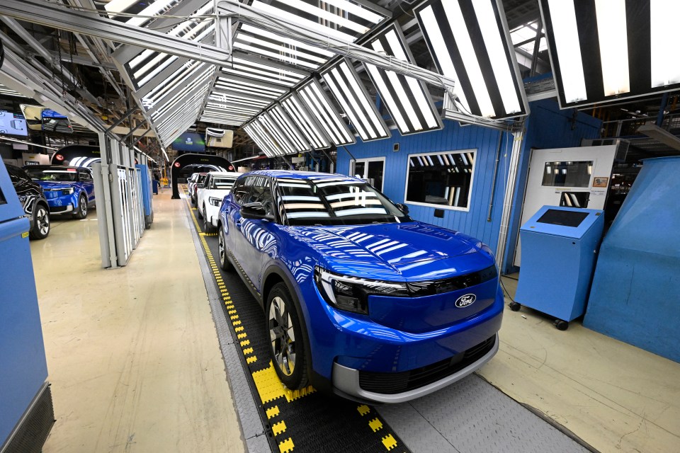 a blue ford car is on a assembly line