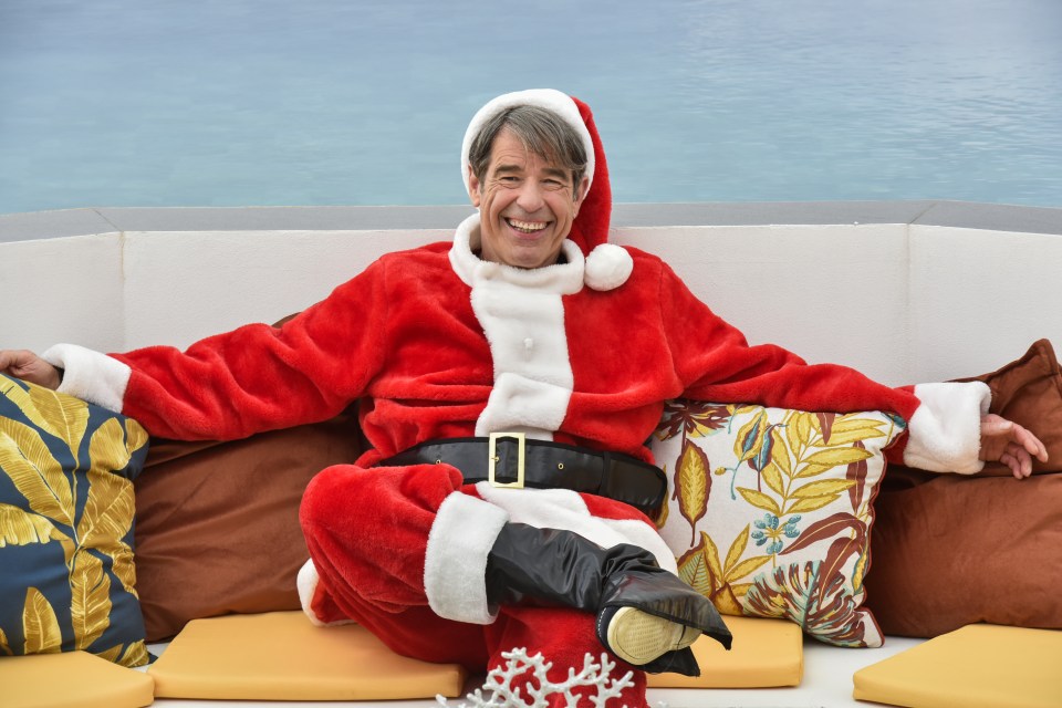 a man dressed as santa claus is sitting on a couch