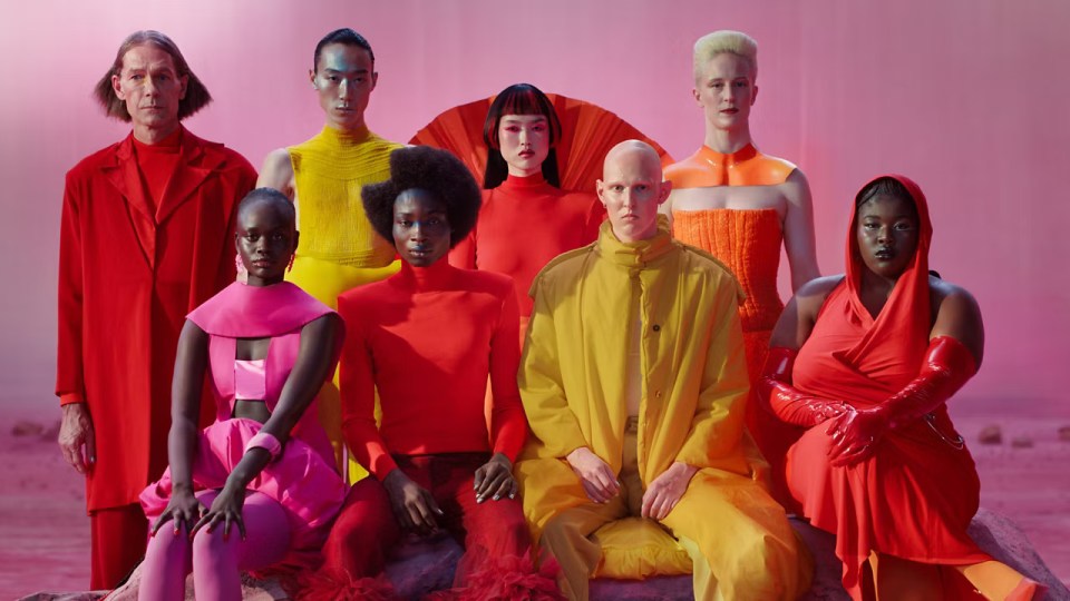 a group of people dressed in different colors are posing for a picture