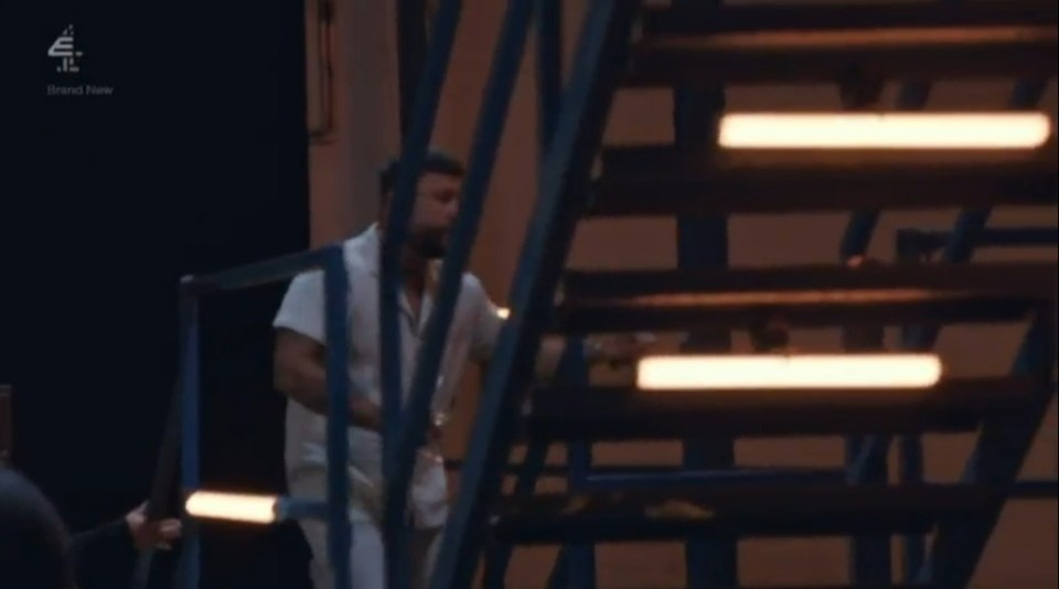 a man in a white robe is walking down a set of stairs .