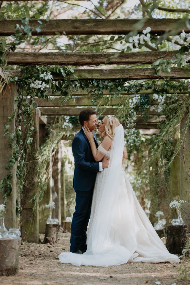 Stacey Solomon stuns in princess gown in first photos of 'special' wedding to Joe Swash, , The couple exchanged vows in front of friends and family at an intimate ceremony in the garden of their beloved Pickle Cottage., , In the first image taken by Chelsea White Photography, Stacey and Joe are holding hands as they laugh with one another as husband and wife., , Stacey, 32, looks stunning in an off-white princess gown which features a tulle floor-length skirt and corset-style top with spaghetti straps as well as draped sleeves.