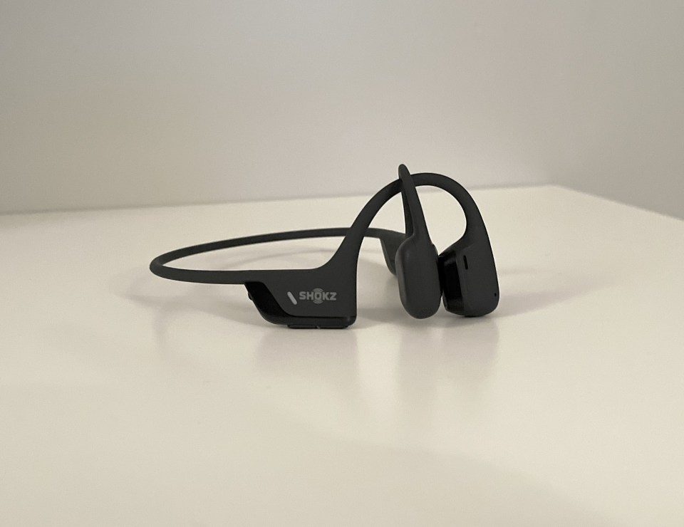 A pair of Shokz OpenRun Pro 2 headphone sit on a white table