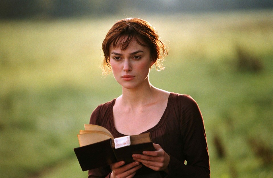a woman is reading a book in a field with a watermark that says ' shutterstock ' on it