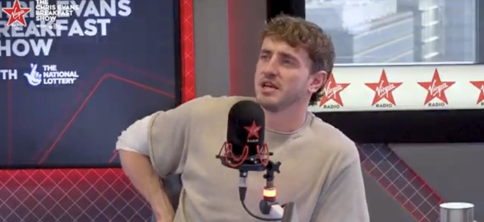 a man stands in front of a virgin radio microphone