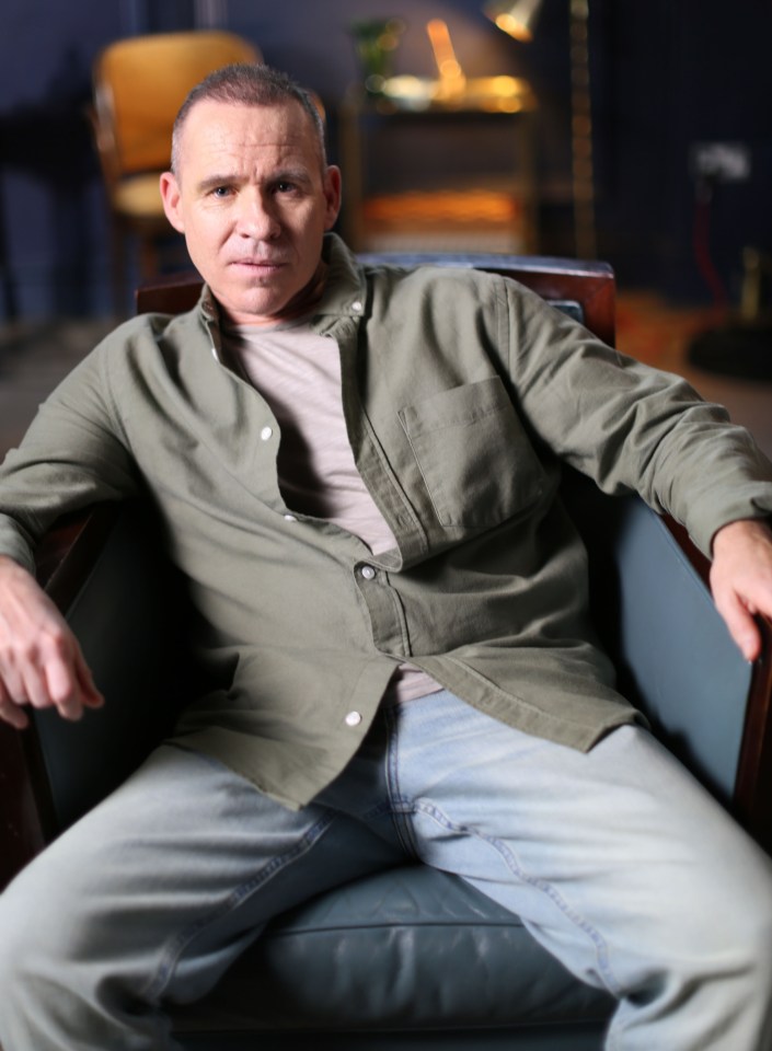 a man in a green shirt is sitting in a chair