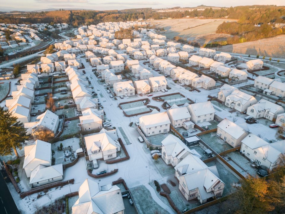 an aerial view of a residential area covered in snow