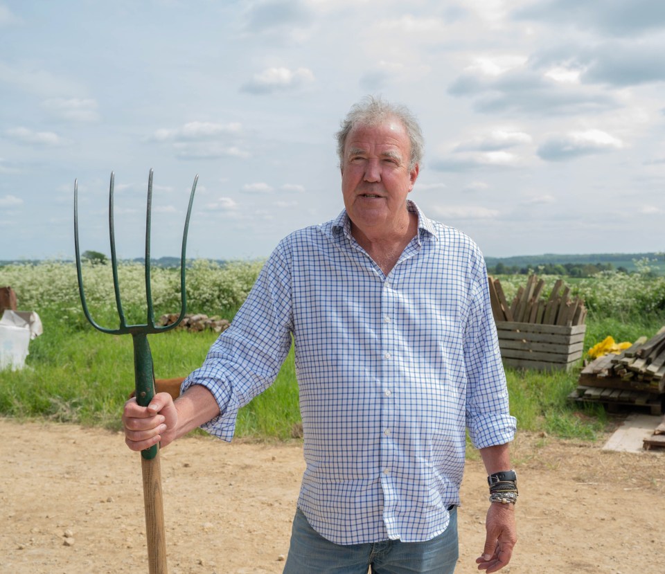 a man in a plaid shirt is holding a pitchfork