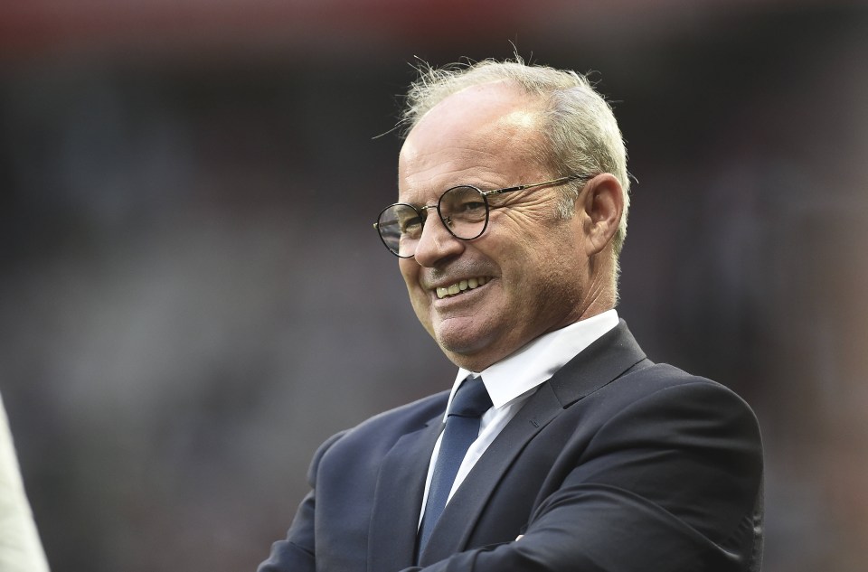 a man wearing glasses and a suit is smiling