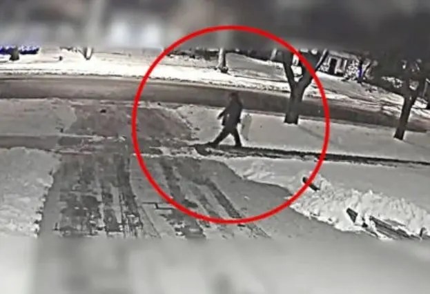 a person is walking down a snowy sidewalk in a red circle .