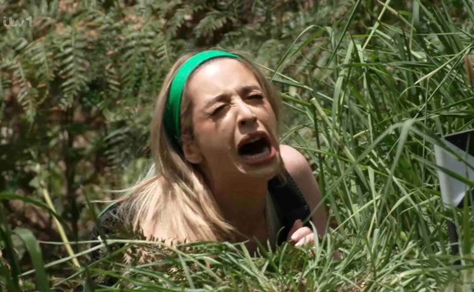 a woman in a green headband is screaming in the grass