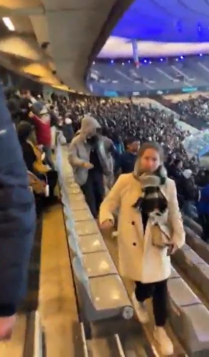 a woman is walking down an escalator in a crowded stadium .