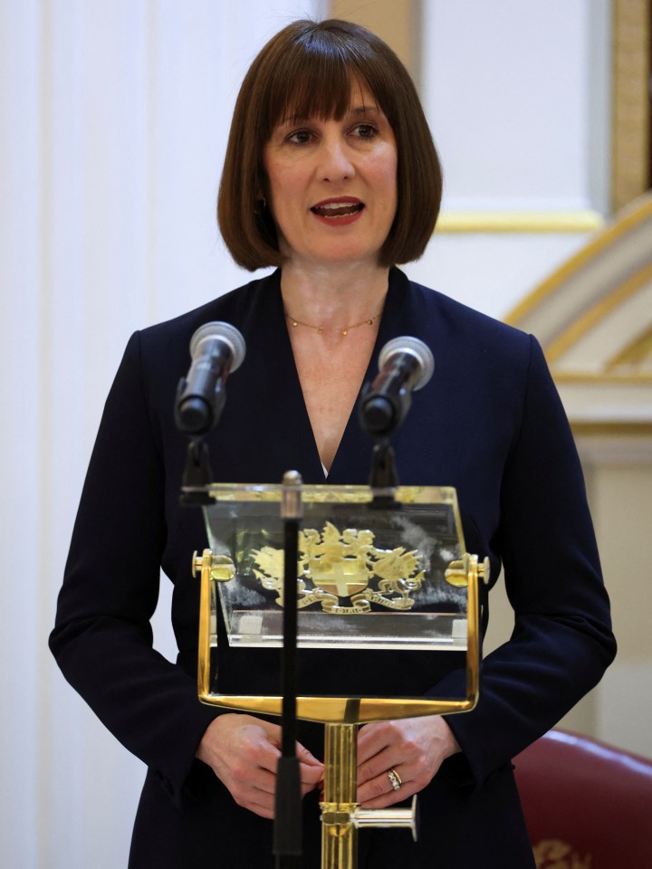 a woman stands at a podium with a shield on it