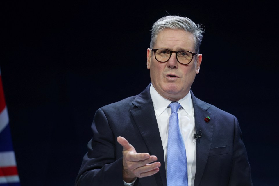 a man in a suit and tie is speaking into a microphone