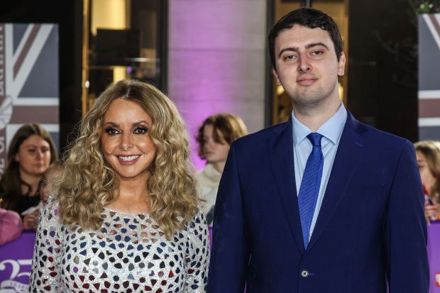 a woman in a sequined dress stands next to a man in a blue suit