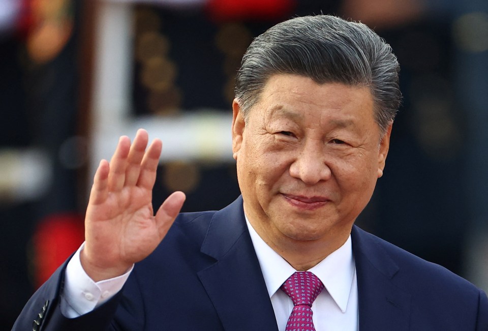 a man in a suit and tie is waving his hand