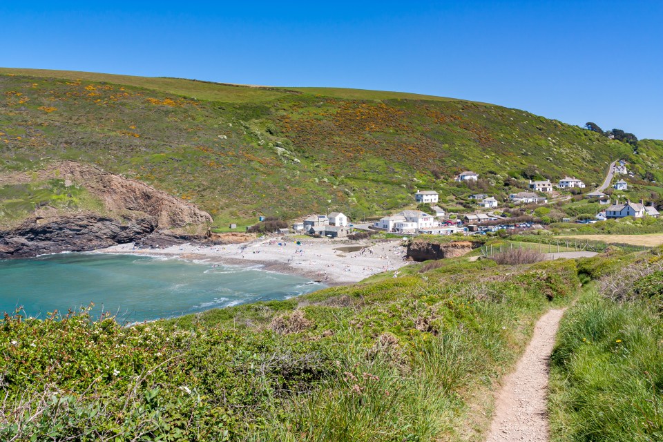 a path leading to a small village on a hillside
