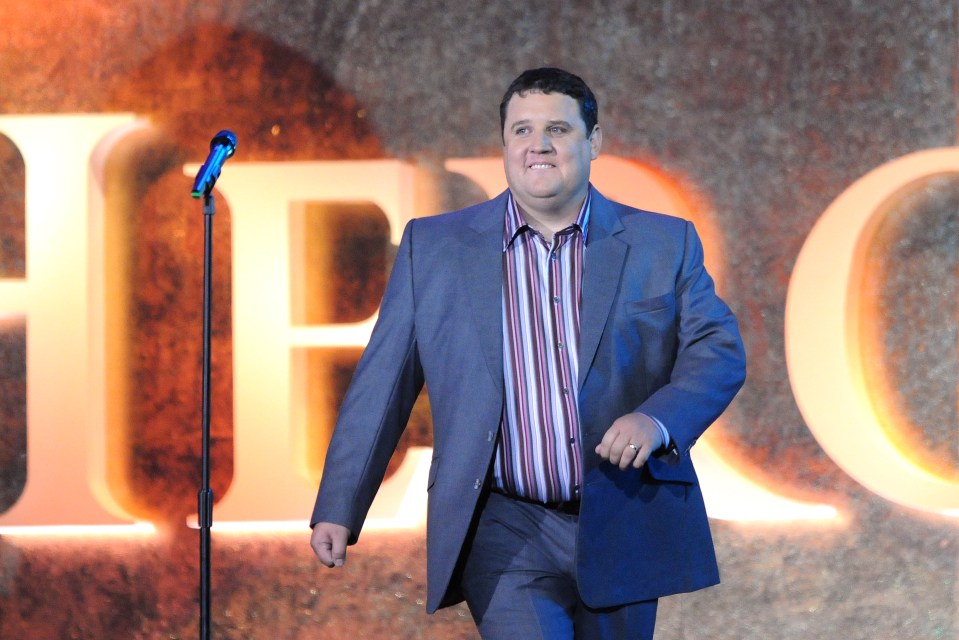 a man in a suit stands in front of a microphone