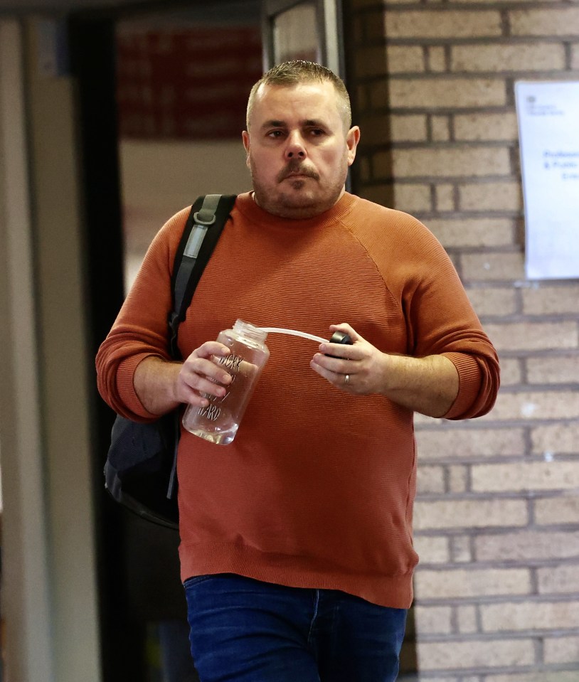 a man in an orange sweater is holding a bottle that says ' i love you ' on it