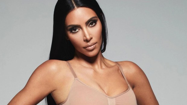 a woman with long black hair is wearing a tan bra